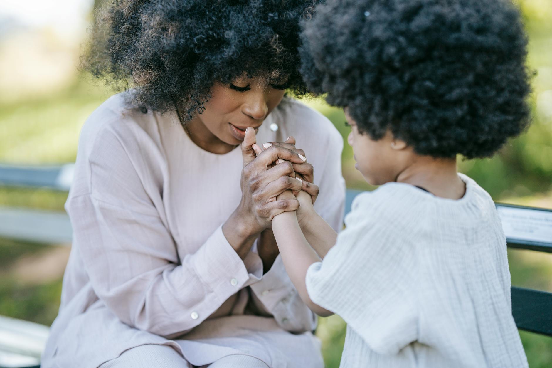 a woman and a young girl praying together