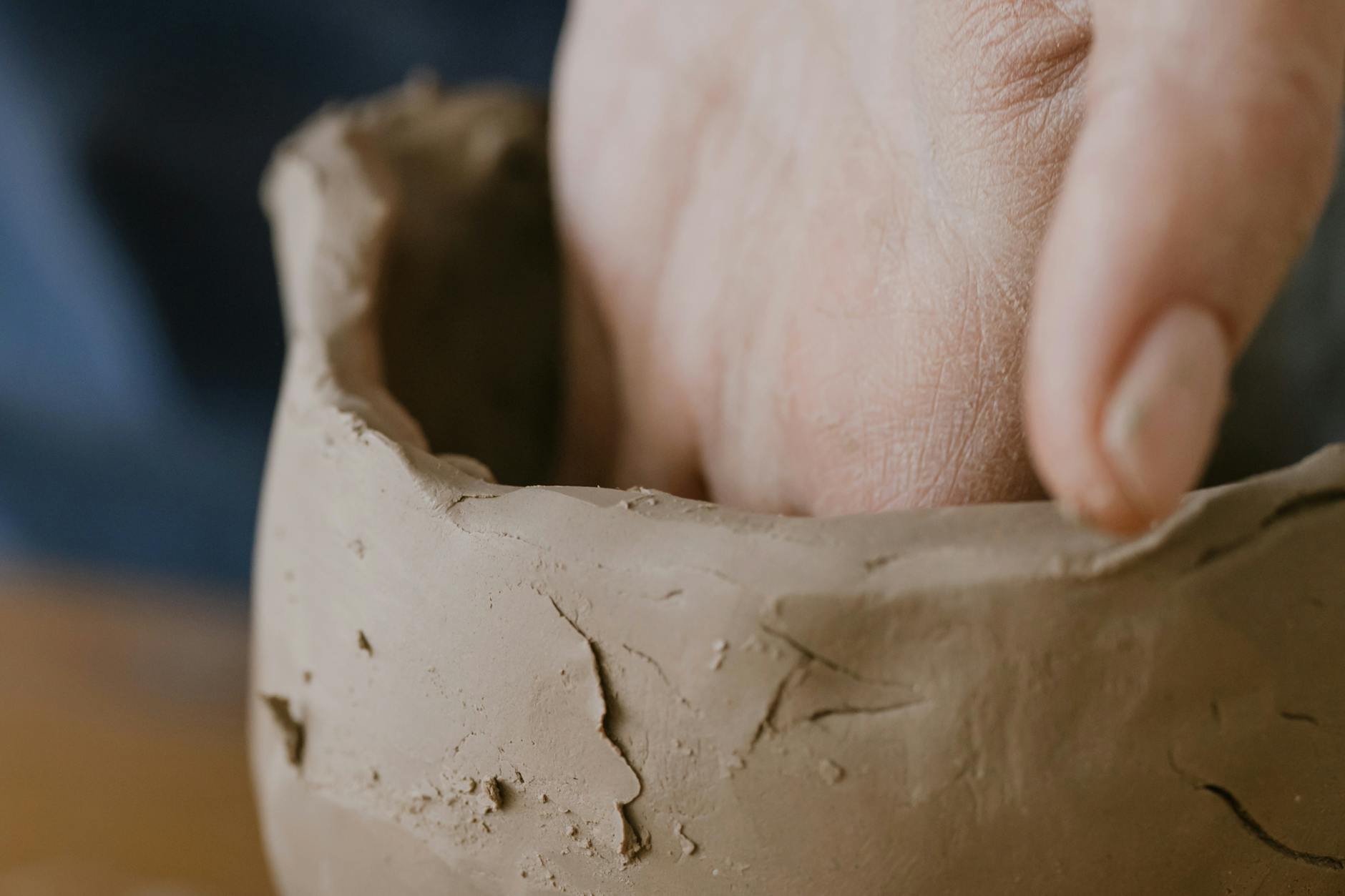 a person shaping a clay