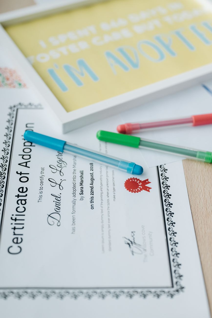 certificate of adoption on brown wooden table