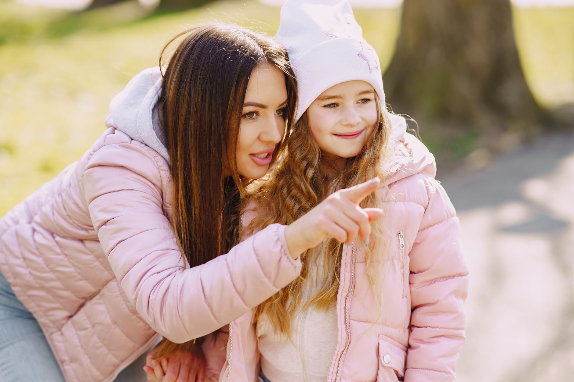 happy young mother and little daughter in park