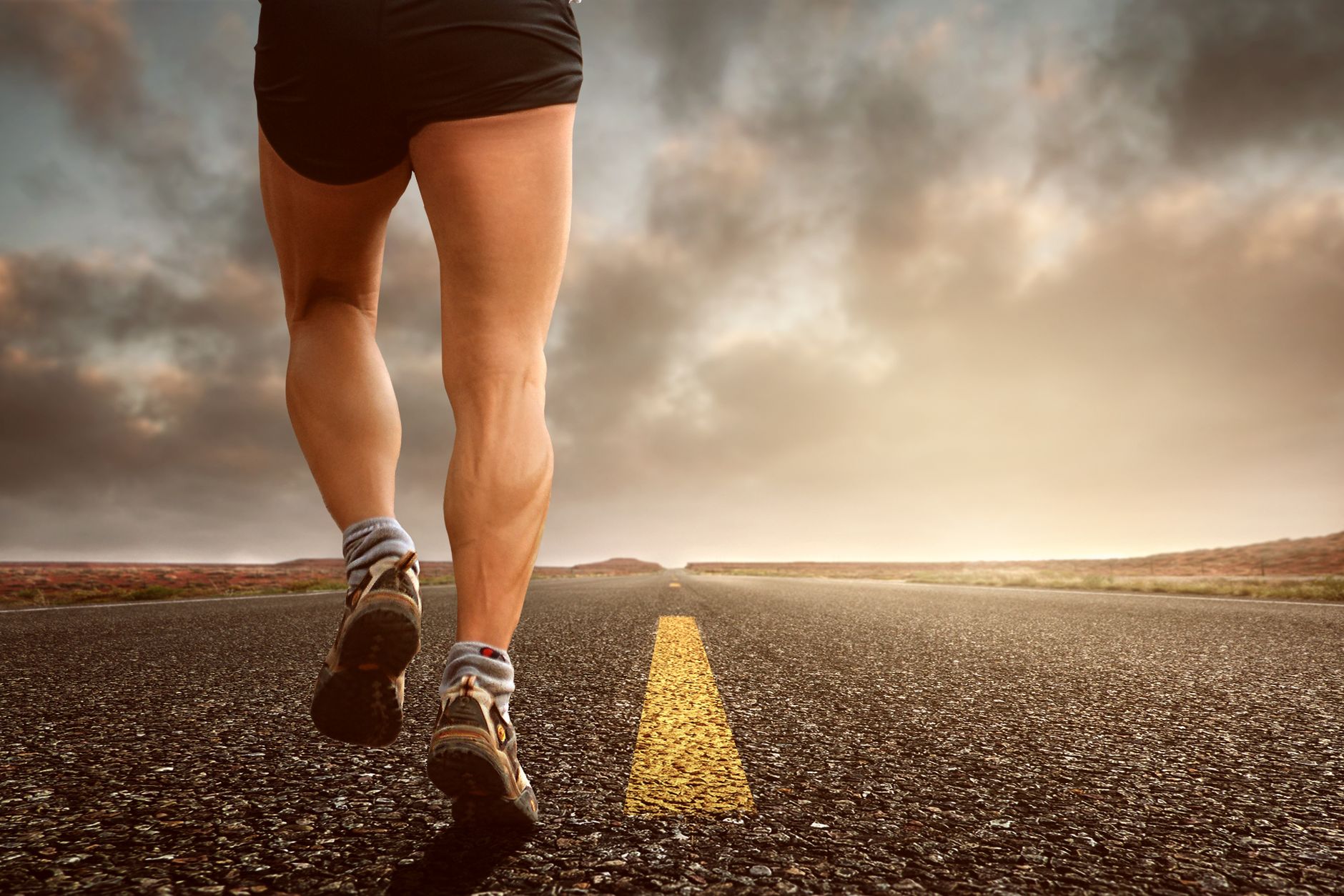 low angle photography man walking on asphalt road