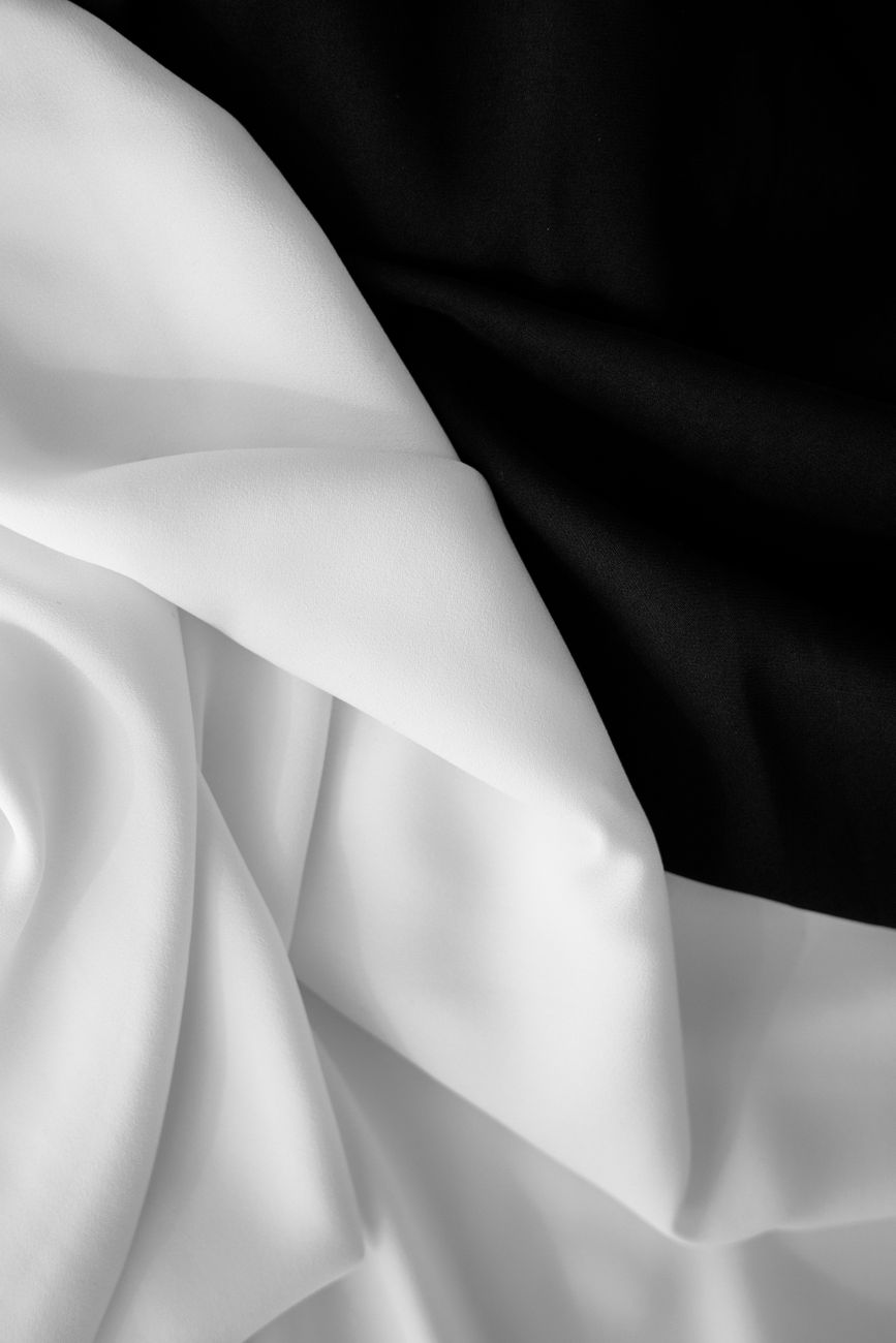 wavy white fabric lying on a black curtain